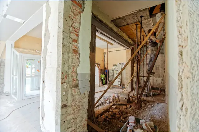 Builders working inside a gutted building during renovation