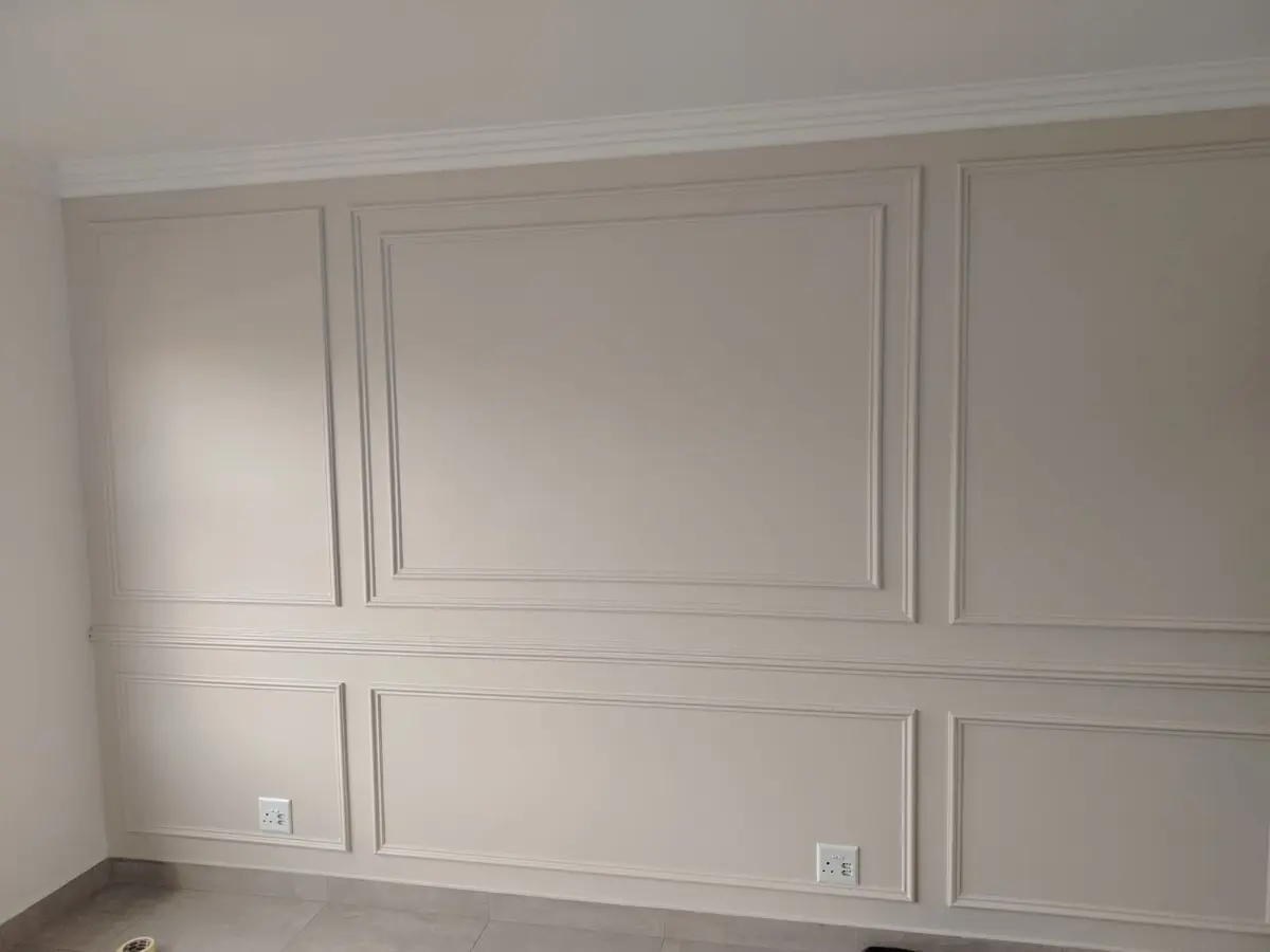 Room wall with painted decorative panel mouldings and cornice