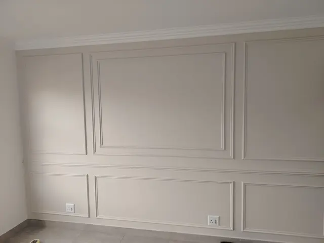 Room wall with painted decorative panel mouldings and cornice