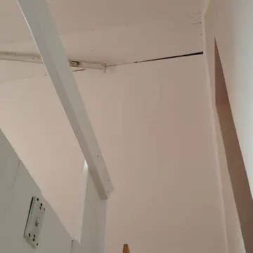 High ceiling of white painted timber planks with a white beam